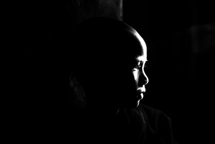 Atmospheric portrait of a monk using reflected light falling on the face