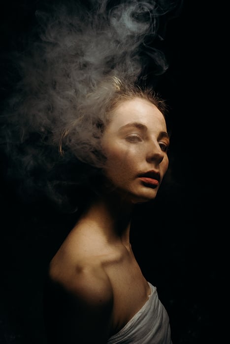 A moody portrait of a girl, with smoke used to create a dramatic effect
