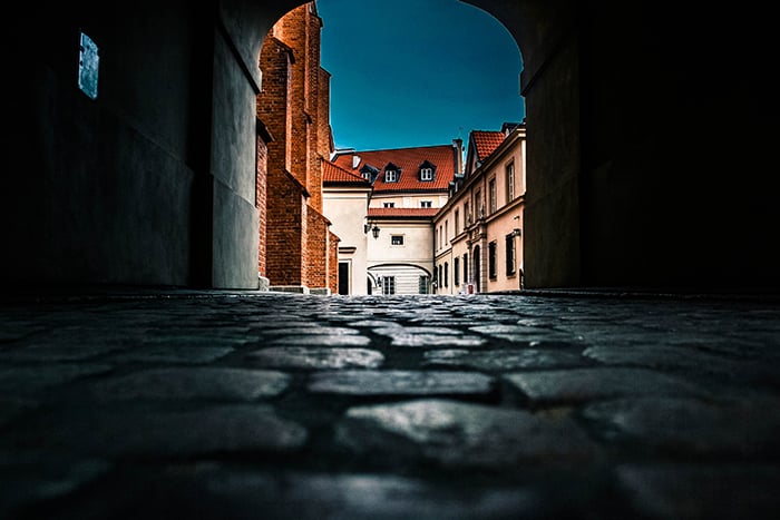 An archway over a cobbled street shot from a low angle