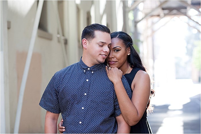 A woman hugging a man from behind during engagement photo session