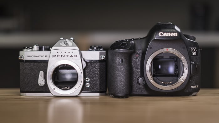 Two DSLR cameras displayed side by side on a table.