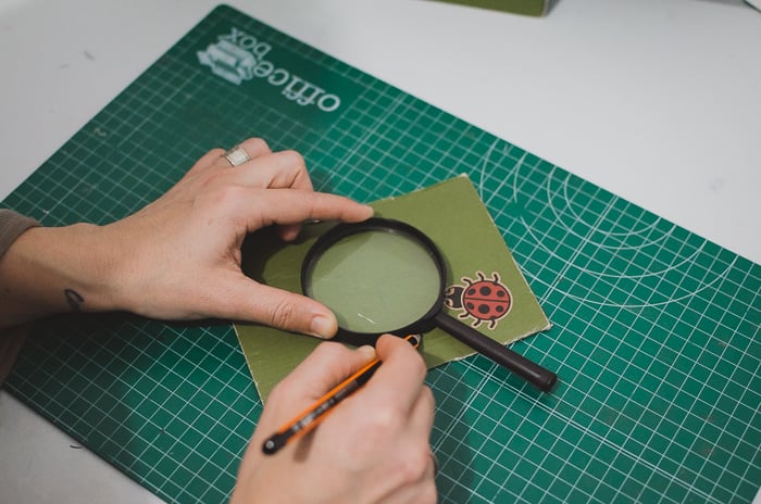 A person cutting cardboard to make a DIY phone projector