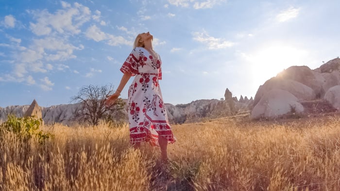 A blonde woman frolicking in fields