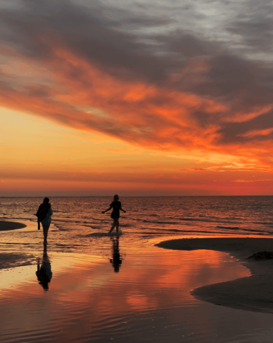 sunset beach photo with two people's silhouettes taken with an iphone