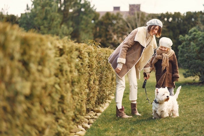 A mother and daughter walking a small dog as an example of family photos with pets