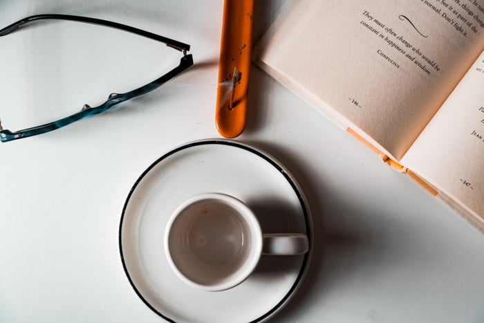 Incense stick behind an empty espresso cup.