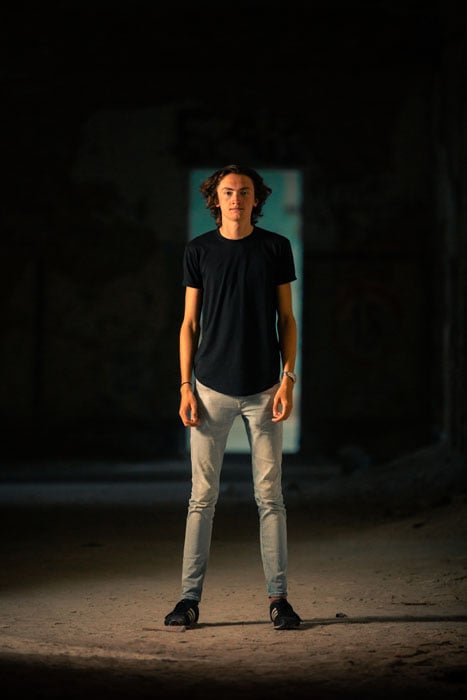 A portrait of a young man standing in a doorway