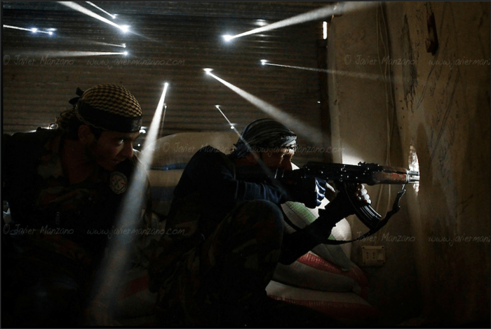 Two men in military uniforms in a dimly lit room.