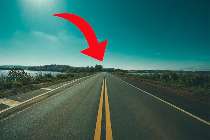 photo of an empty road with a red arrow showing vanishing point on the horizon line