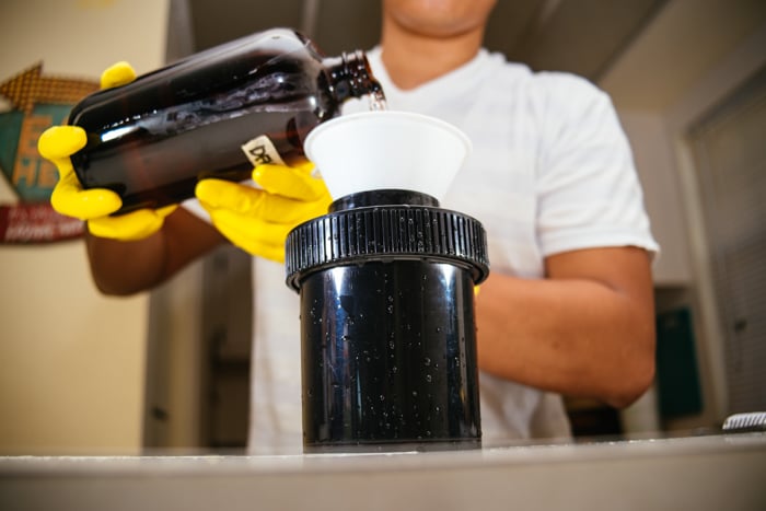 an image of a man with yellow gloves in the pre soak process of developing film at home