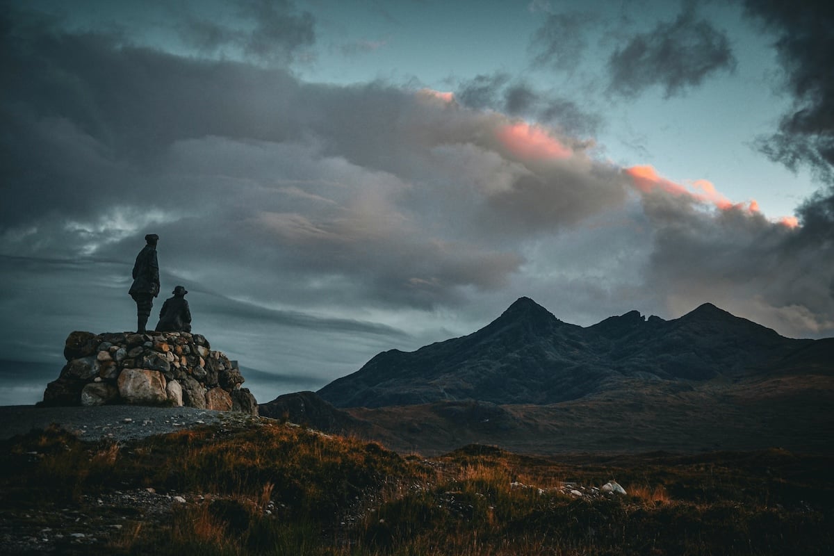 Two people standing on a rock looking at a mountain in the distance showing size and distance for visual weight