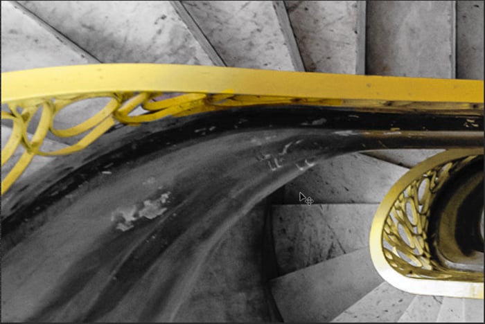 A detail of a spiral staircase with a brighter yellow bannister for Photoshop selective color process