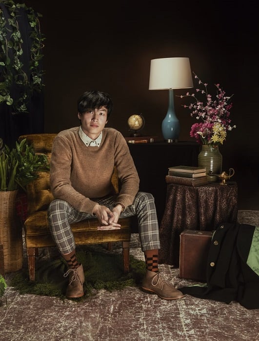 Fashionable and stylized studio portrait of a man sitting in a chair for editorial style photography