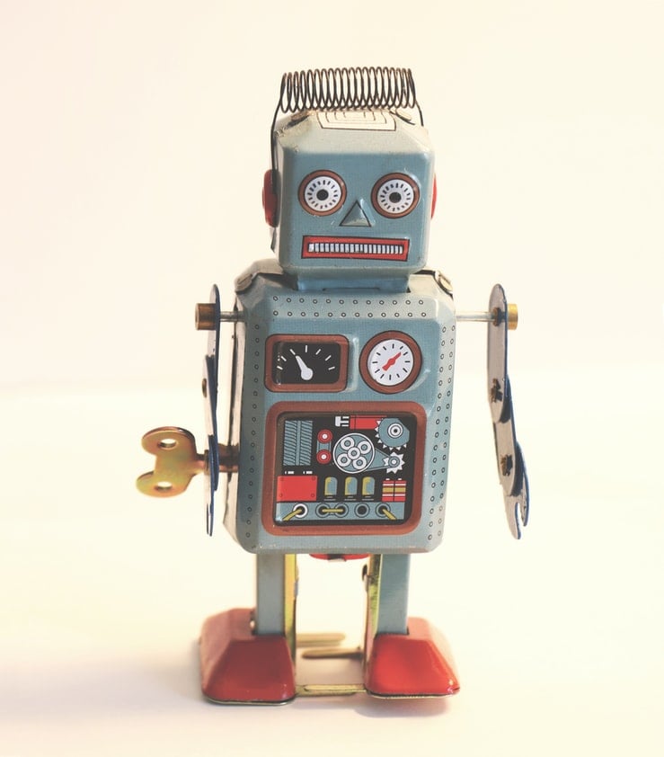 A robotic toy with a vintage aesthetic, featuring a prominent clock on the chest.