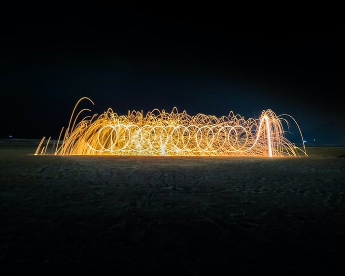 Light painting at night with orange light creating an effect of fire