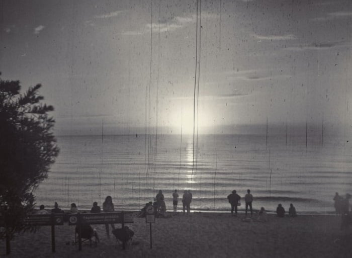 black and white film photograph of a seafront sunset
