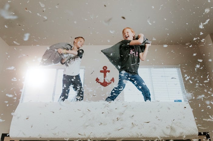 photo ideas for siblings: siblings having a pillow fight