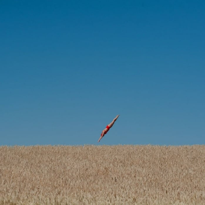 A composite image of a woman diving into a wheat field 