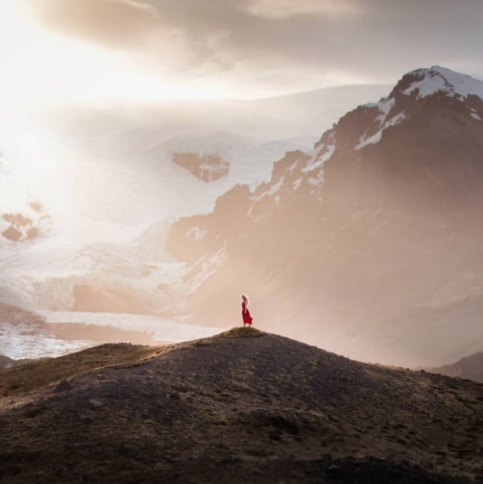 Woman standing on hilltop in mountainous landscape as an example of fairy tale photography