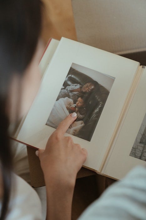 Woman looking through a photo album with 4x6 photo print in it