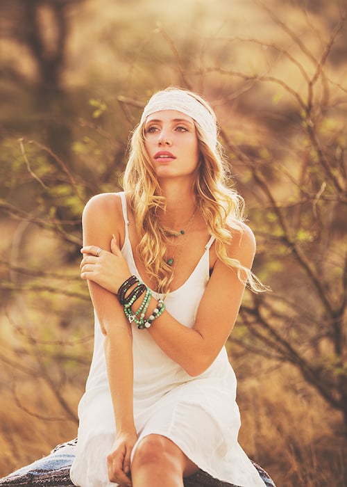 Fashion photo shoot of a beautiful young woman backlit at sunset
