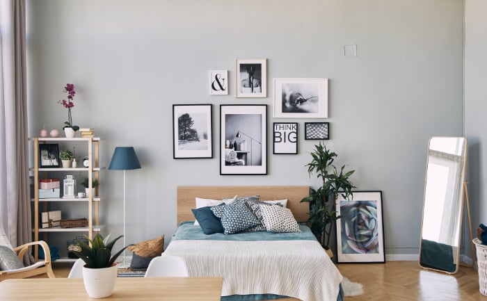 A modern bedroom with several framed photos over the bed
