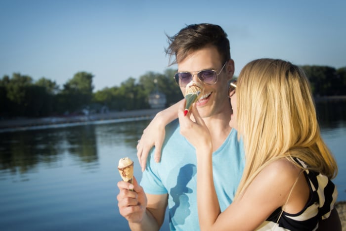 Young woman squashing an ice cream on her boyfriend's nose Young woman squashing an ice cream on her boyfriend's nose