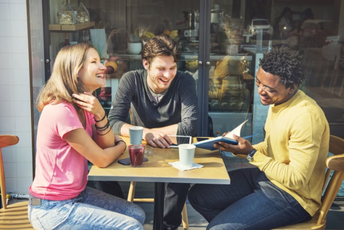 Three people meeting outside a coffee shop Three people meeting outside a coffee shop