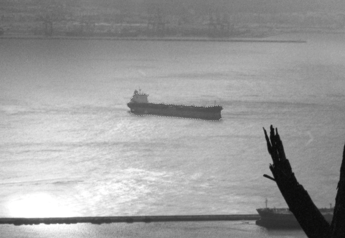 A ship crossing the ocean, viewed from the shore.