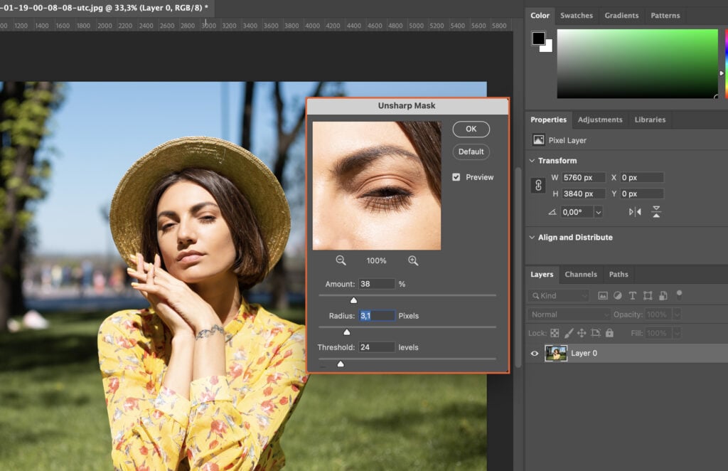 A woman poses for a portrait, with her image displayed on a computer screen and overlaid with filters in a photo editing software.