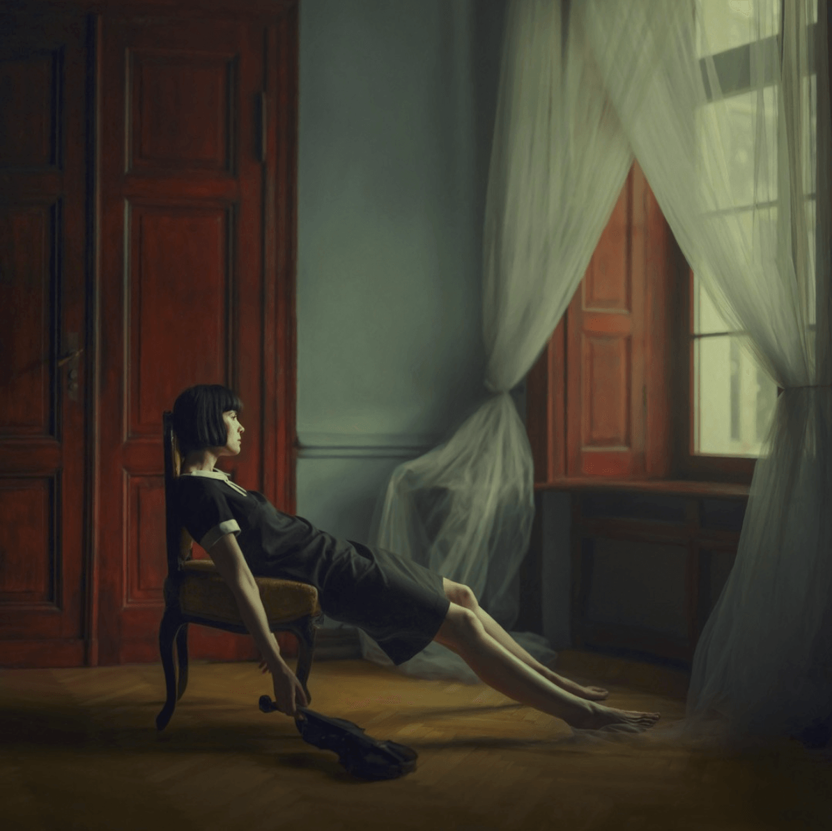 A woman holding a violin and lounging in a chair in front of a window