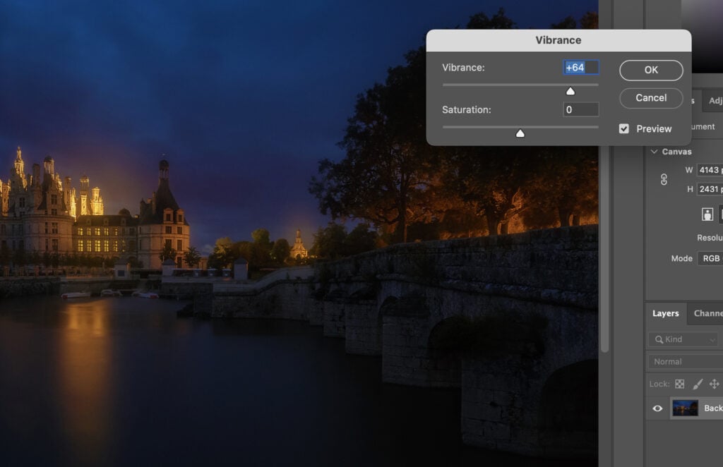 A photo editing software program, where the user is adjusting the vibrance of a nighttime cityscape photograph.