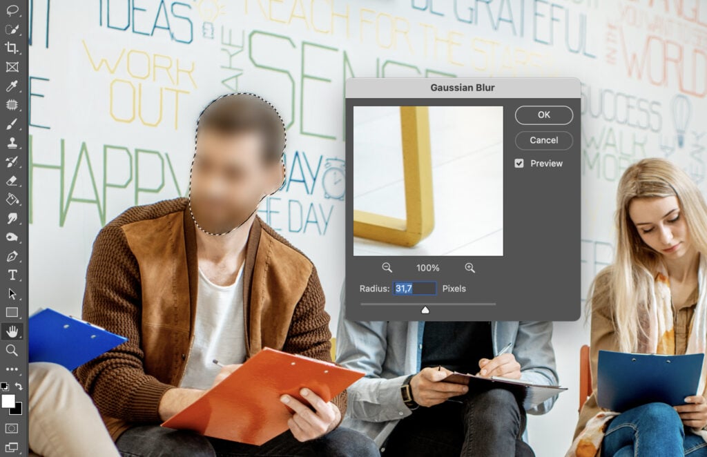 Adobe Photoshop interface open, displaying a photo of three people sitting together in a modern indoor setting.