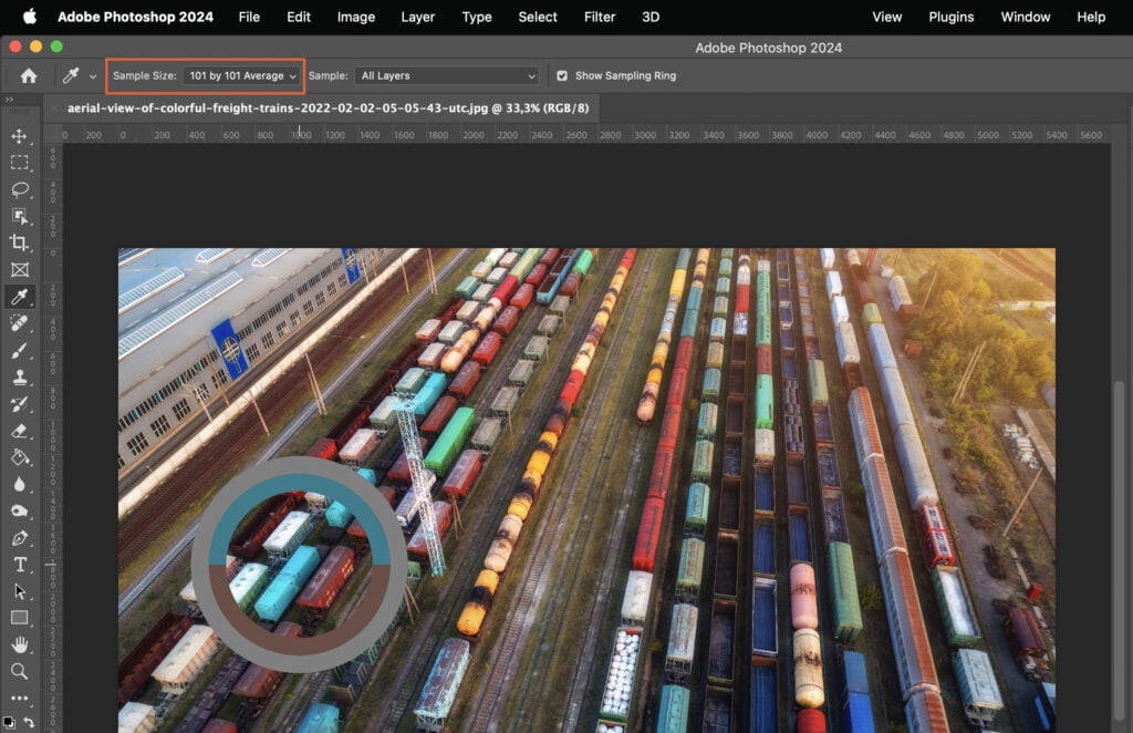 A train yard filled with numerous colorful cargo trains, presented in an Adobe Photoshop window with various layers and adjustments visible. 