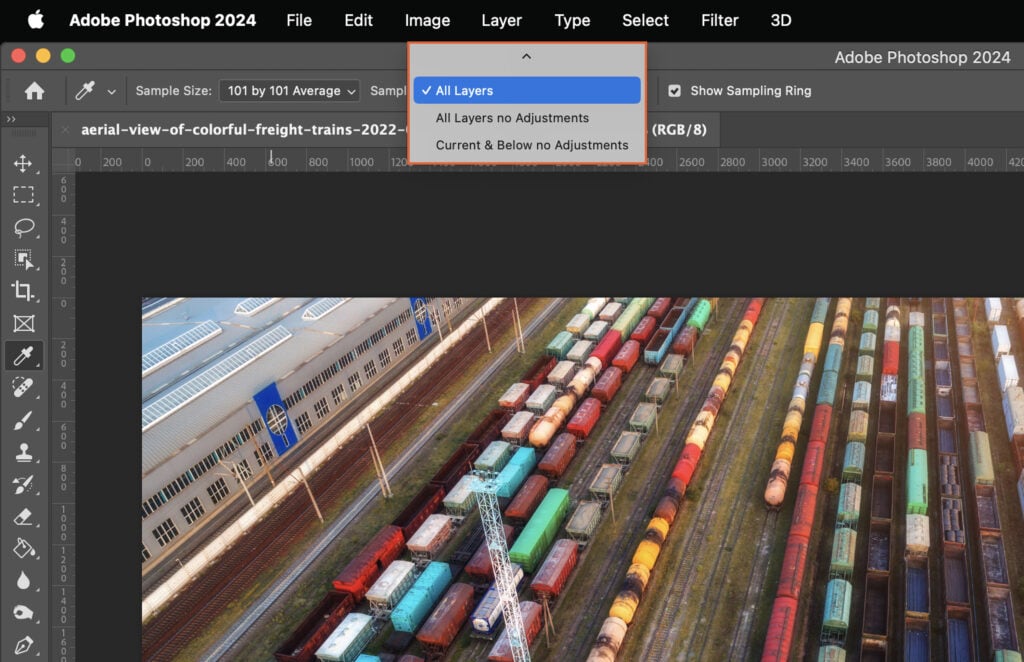 Photoshop program open and an image of cargo train cars displayed.