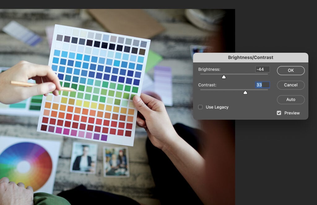 A person holding a palette with various colors, possibly selecting the colors for a graphic design project.