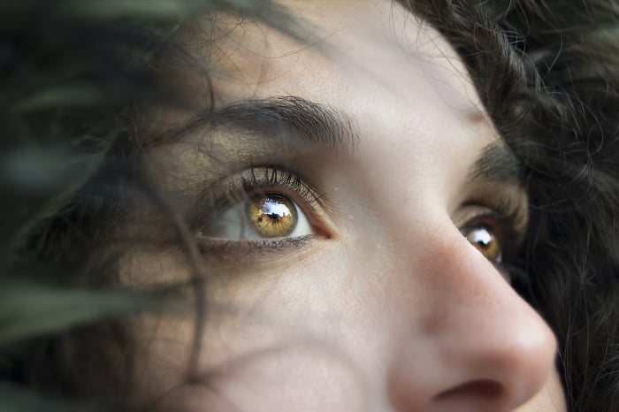 Close-up portrait of a woman's light brown eyes.