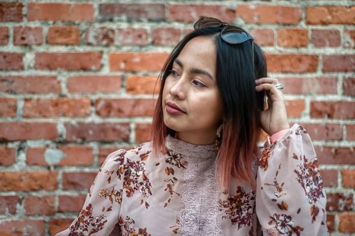 HDR portrait of a woman in front of a brick wall