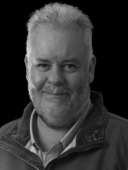Three-light headshot of middle-aged man in black and white