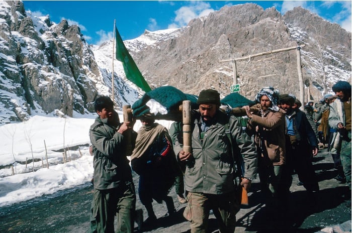Men marching on mountain road