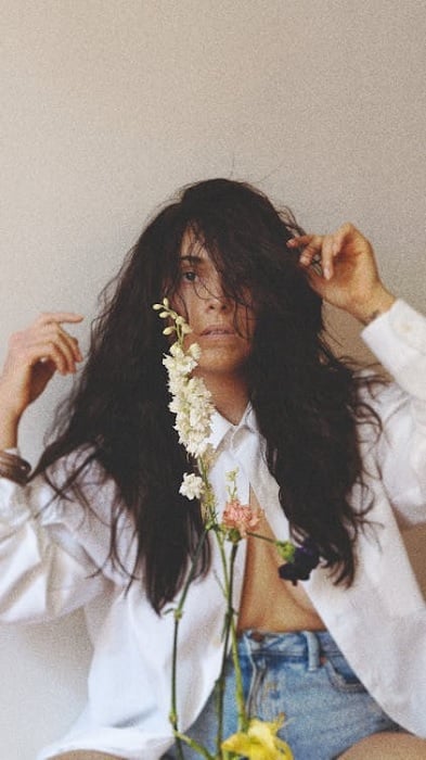 Self portrait of a woman with messy hair and unbuttoned shirt