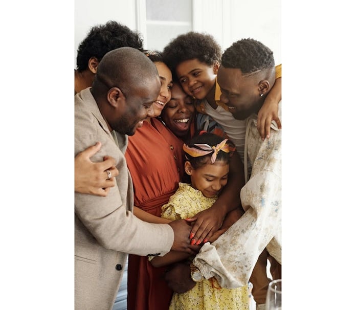 Seven members of a family smiling and embracing