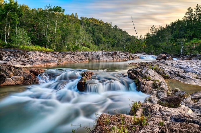HDR image of rocky river flowing through forest
