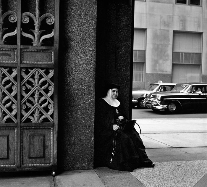 Nun sitting on a street corner