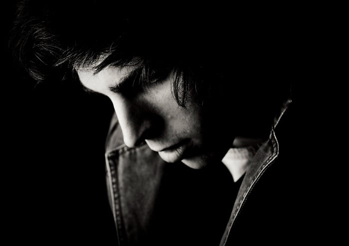 High-contrast portrait of man looking down