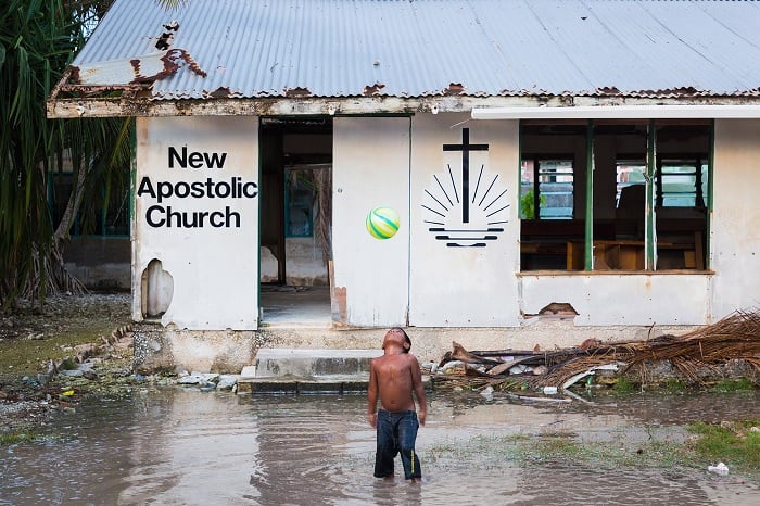 Boy outside flooded shack church