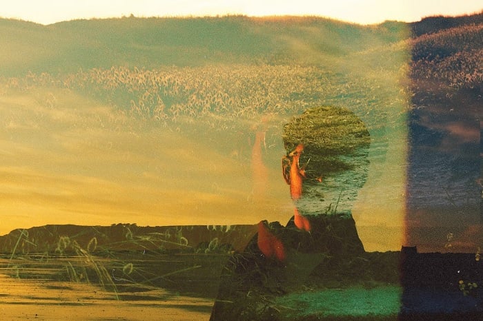 Double exposure of man and hills in golden hour