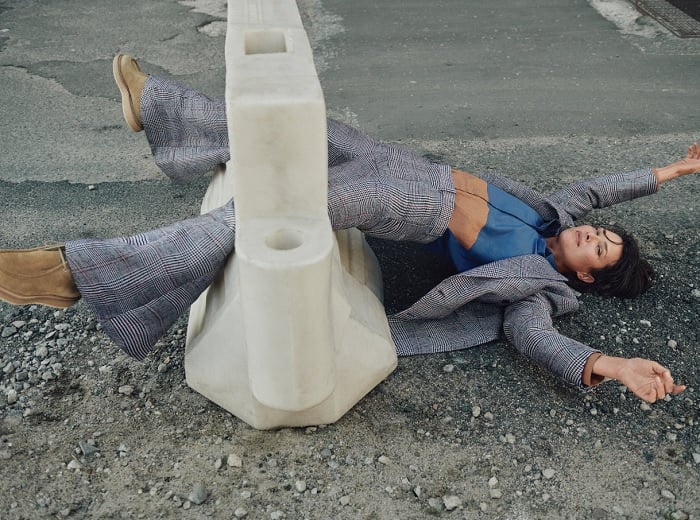 Woman lying on a road with legs stuck in a bollard