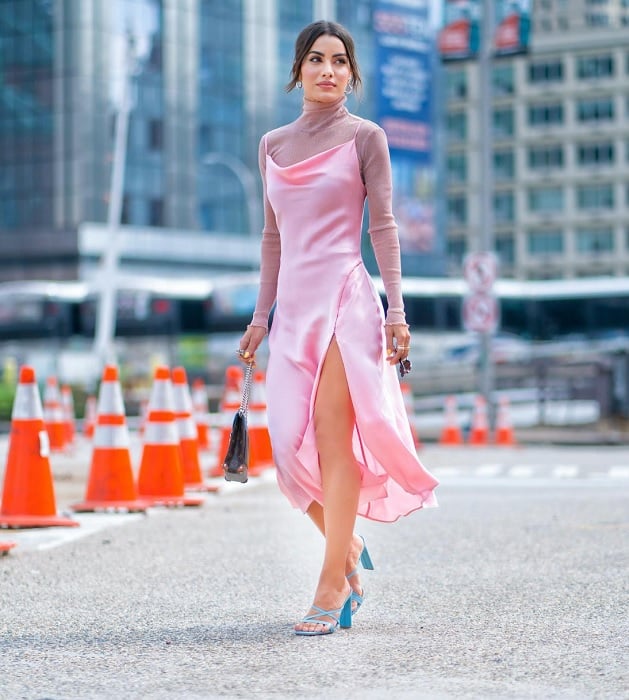 Woman in pink dress walking in front of traffic cones