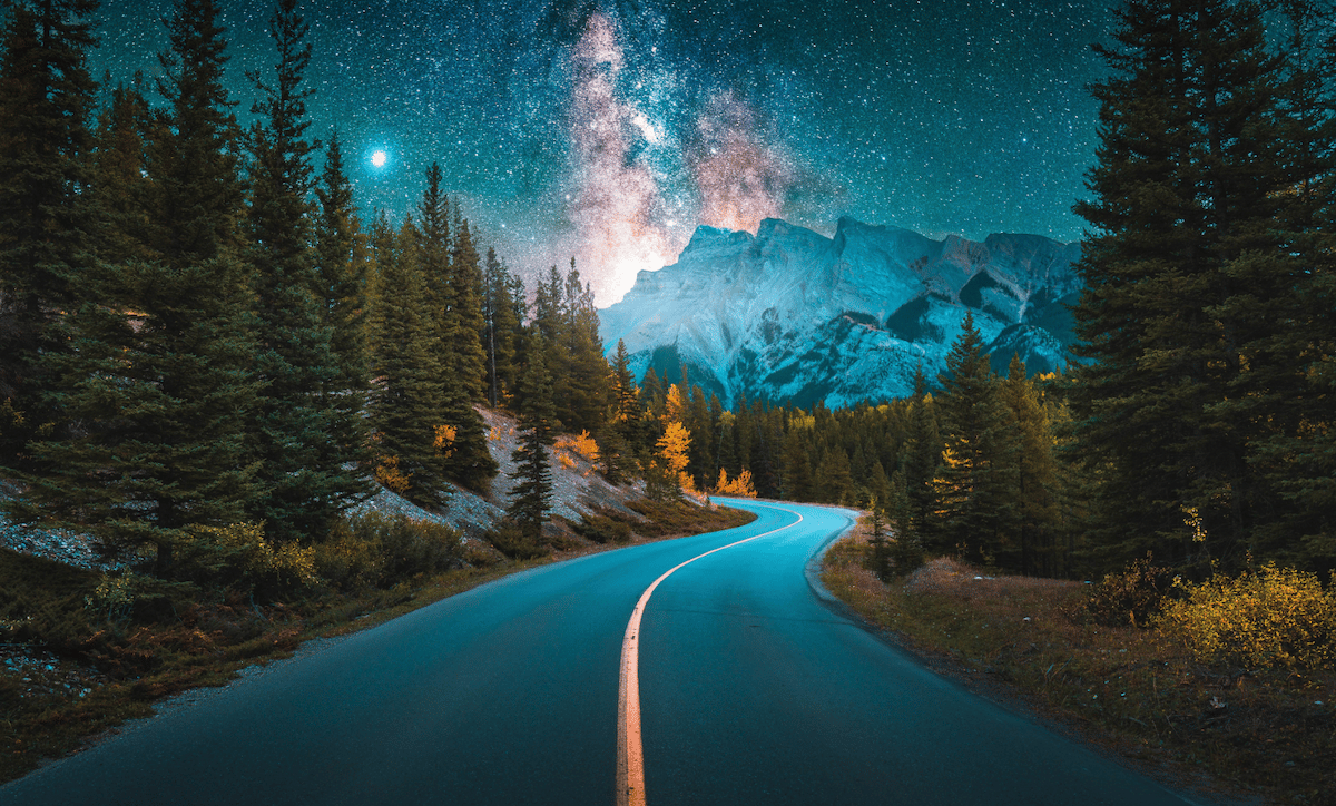 photograph of mountain road at night heavily edited